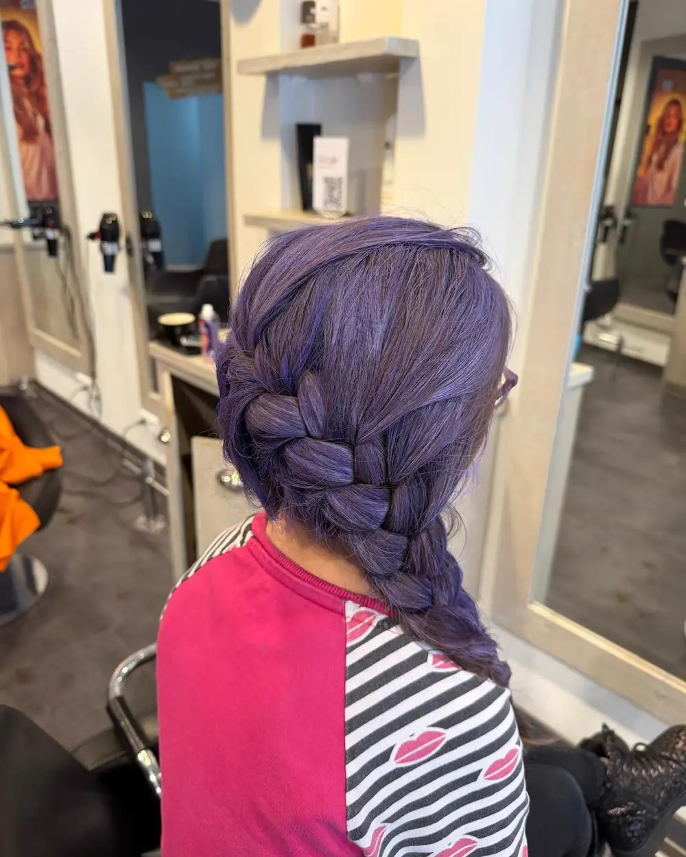 Kind met een paarse vlecht, gevlochten in de salon