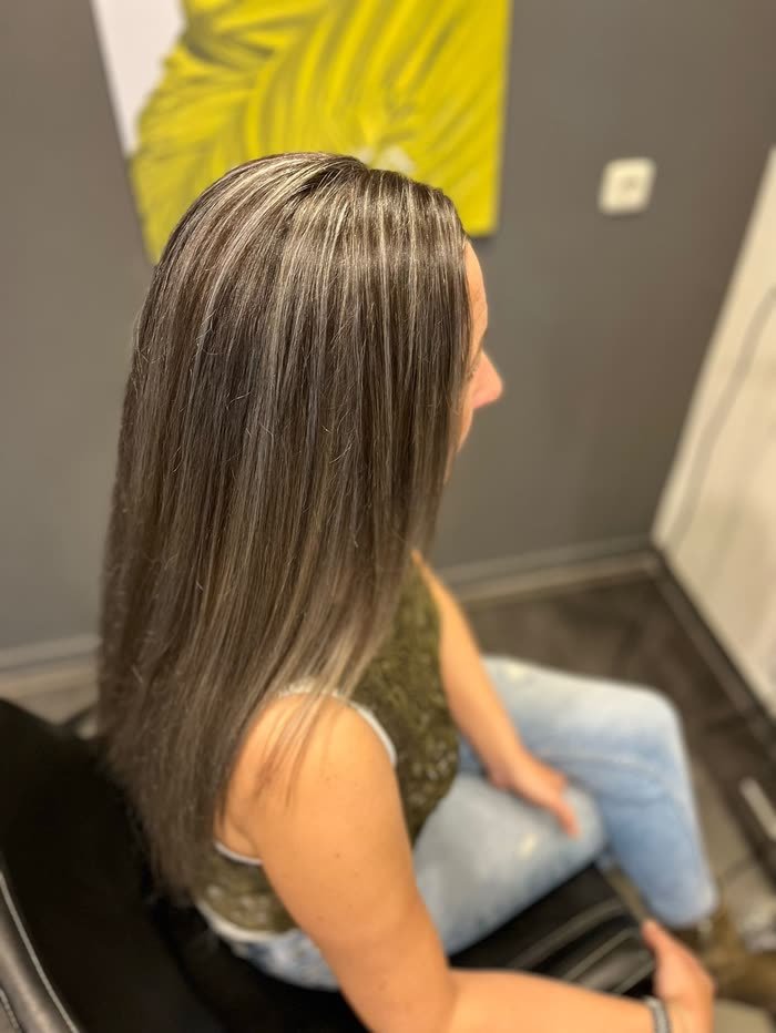 Lang blond haar met highlights, zittend in de kappersstoel